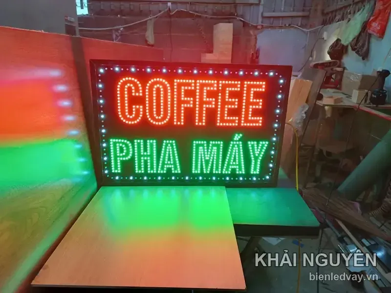 Biển vẫy Coffee Pha Máy nền đen chữ LED đỏ và xanh lá, viền bóng trắng, đặt cạnh ván gỗ