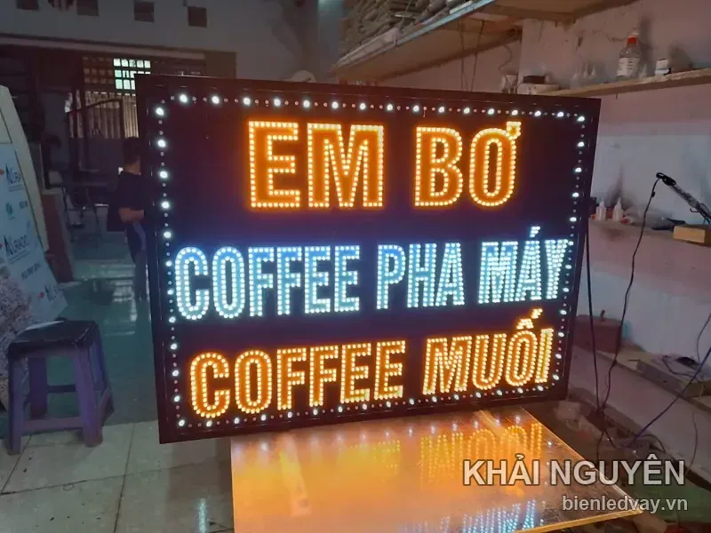 Biển EM BƠ có chữ LED vàng cam, dòng COFFEE PHA MÁY chữ LED trắng và COFFEE MUỐI chữ cam, viền bóng LED màu trắng.
