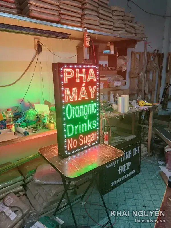 Biển vẫy LED đứng chữ Pha Máy đỏ trắng, Orangnic Drinks No Sugar xanh lá, sáng thử trên bàn trong xưởng