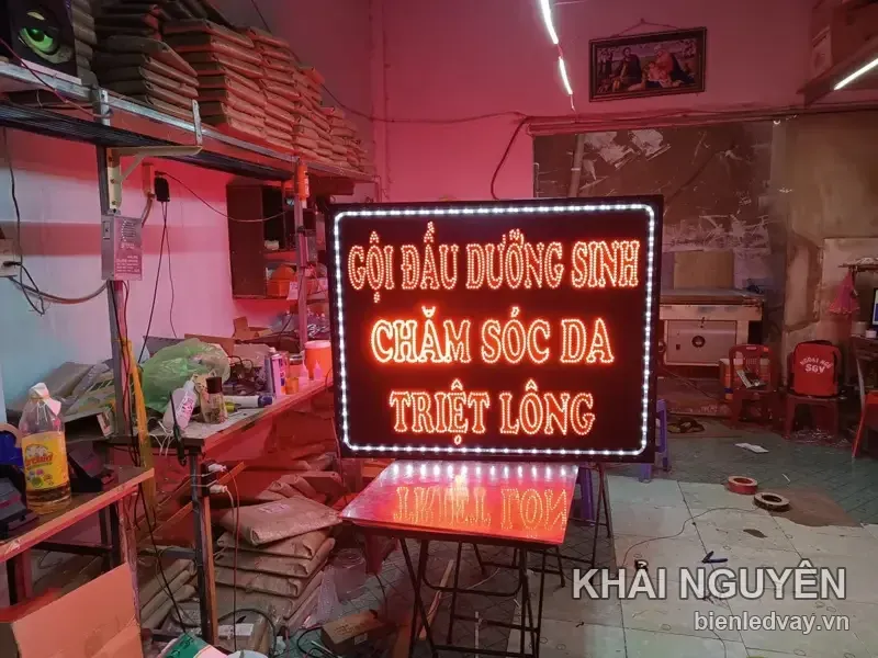 Biển vẫy GỘI ĐẦU DƯỠNG SINH, CHĂM SÓC DA, TRIỆT LÔNG chữ LED cam đỏ, viền bóng trắng dày, dựng trên giá đỡ
