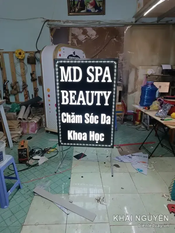 Biển vẫy MD Spa Beauty nền đen chữ trắng Chăm Sóc Da Khoa Học, viền LED bóng trắng, đứng trên chân sắt gấp