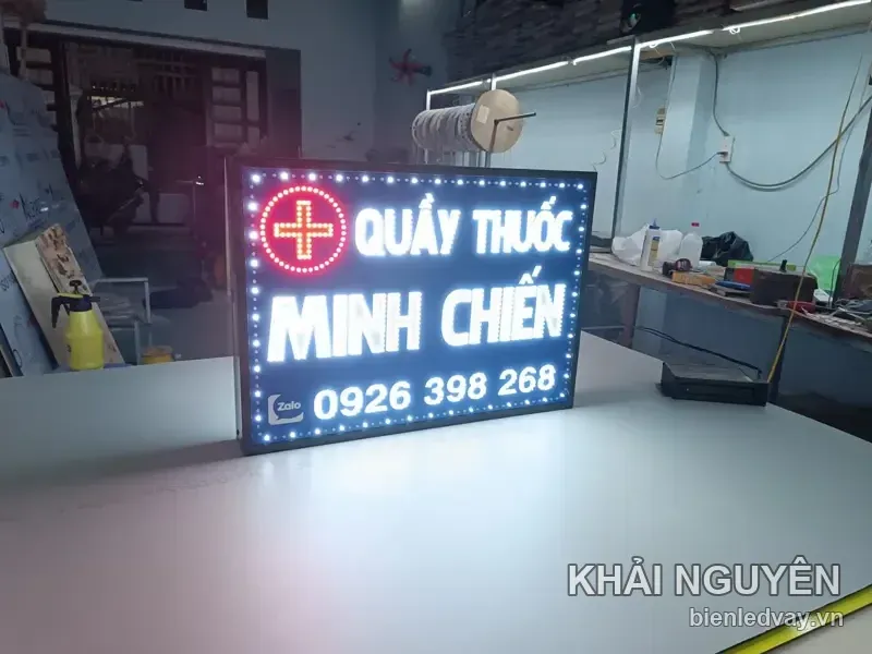 Ảnh chính diện biển Quầy Thuốc Minh Chiến, chữ trắng nổi trên nền tối, chữ thập đỏ, dòng Zalo và số liên hệ ở dưới cùng