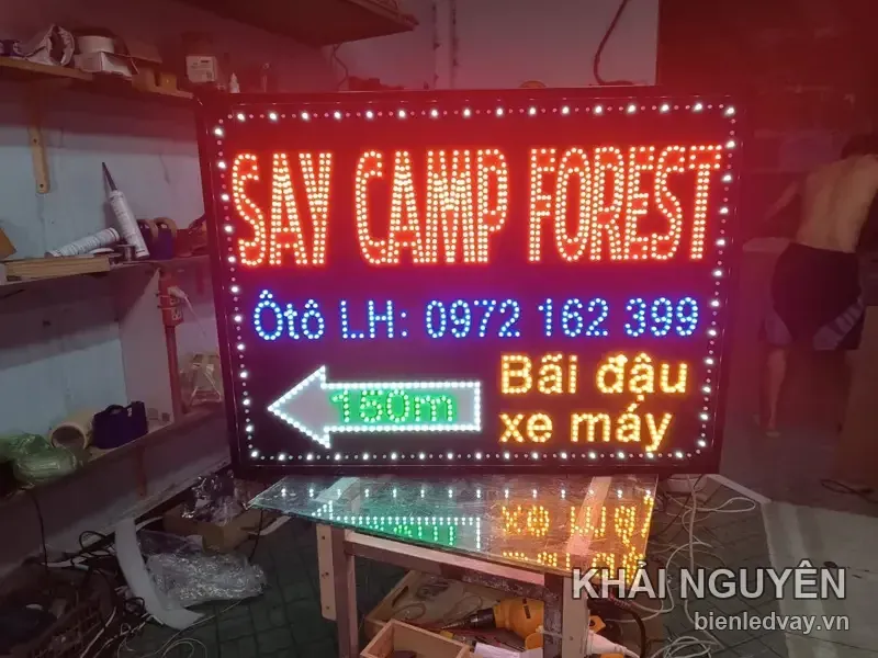 Biển vẫy Say Camp Forest ghi số liên hệ, mũi tên xanh 150m và dòng Bãi đậu xe máy