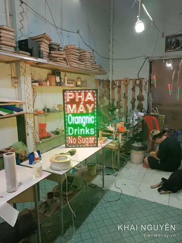 Biển vẫy LED khổ đứng có chữ PHA MÁY đỏ, Orangnic Drinks xanh lá và No Sugar, viền bóng LED tròn màu vàng.