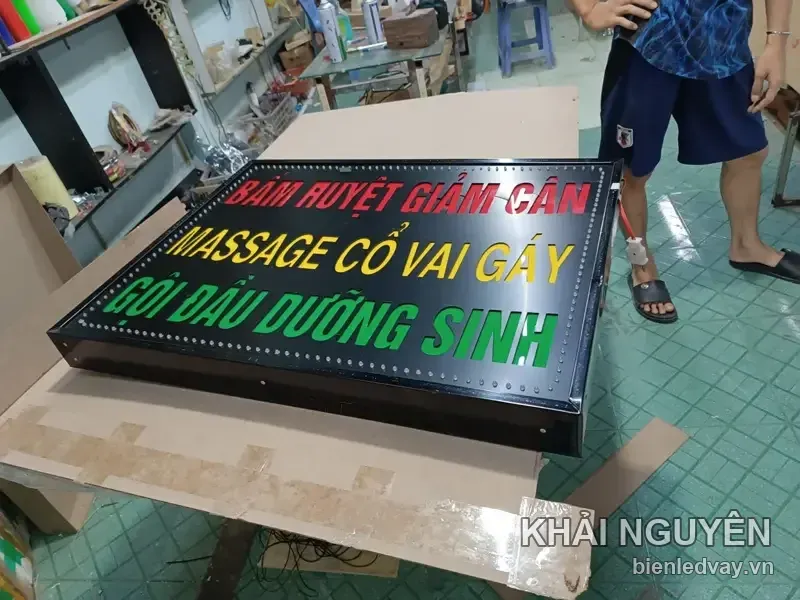 Biển vẫy nền đen ba dòng chữ LED: BẤM HUYỆT GIẢM CÂN đỏ, MASSAGE CỔ VAI GÁY vàng, GỘI ĐẦU DƯỠNG SINH xanh lá