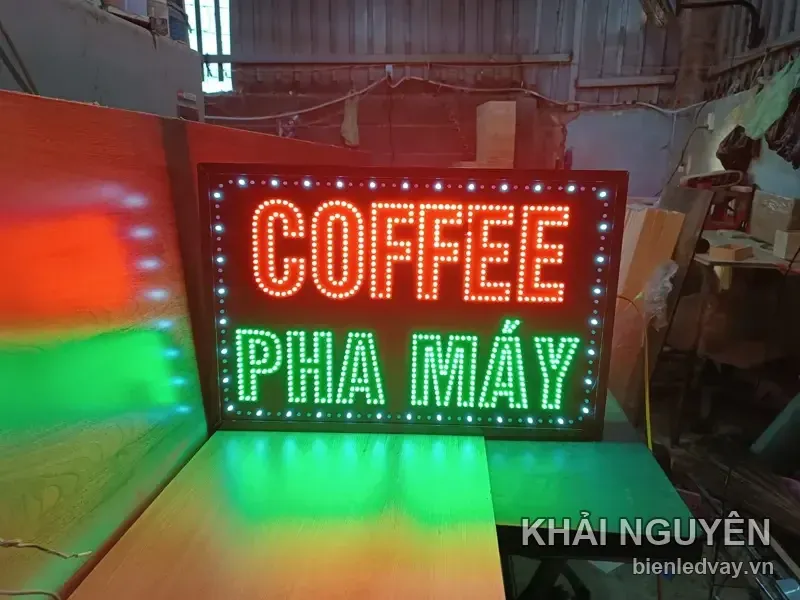 Cận cảnh biển vẫy COFFEE PHA MÁY, phần chữ LED cam và xanh lá có viền bóng tròn trắng, chụp nghiêng tại xưởng