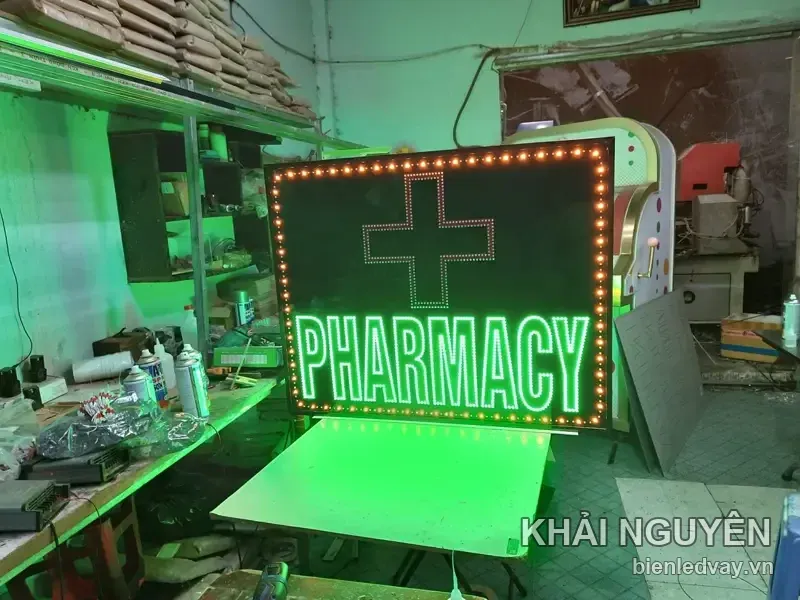 Biển vẫy nhà thuốc chữ PHARMACY xanh lá, chữ thập viền hồng, viền LED bóng tròn vàng, chụp tại xưởng