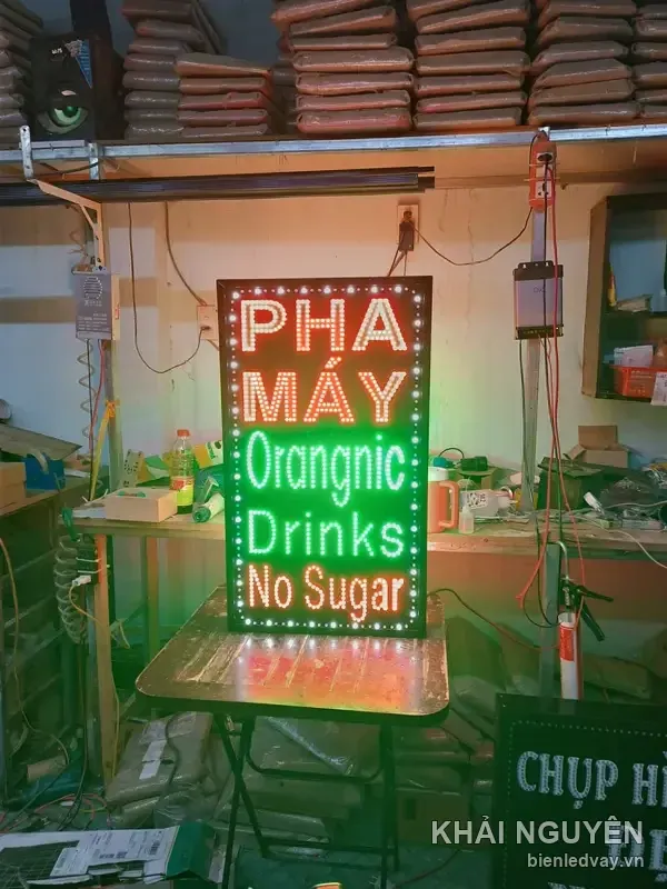 Biển vẫy dọc nền đen, chữ PHA MÁY trắng viền đỏ, Orangnic Drinks No Sugar xanh lá, viền bóng tròn trắng