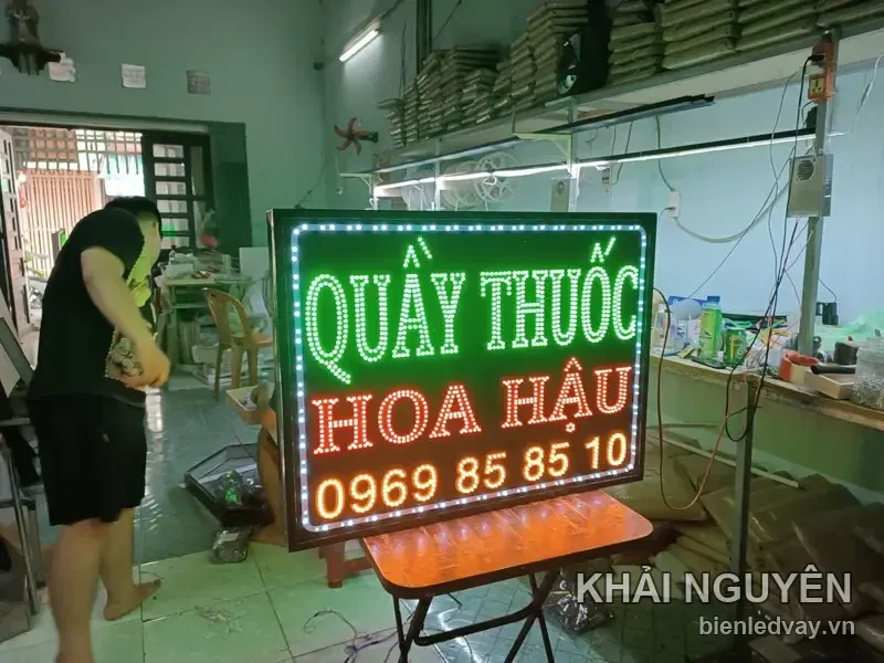 Biển vẫy Quầy Thuốc Hoa Hậu nền đen, chữ xanh lá và cam, có số liên hệ cùng viền LED bóng tròn trắng