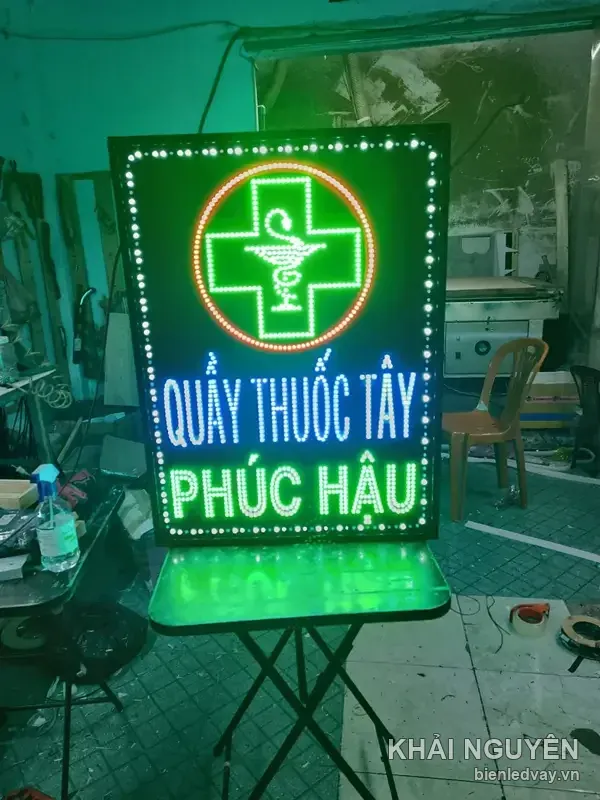 Biển vẫy Quầy Thuốc Tây Phúc Hậu nền xanh dương, chữ trắng, chữ thập xanh trong viền tròn cam, viền LED bóng tròn