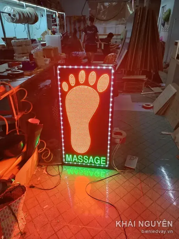 Biển vẫy dáng đứng, hình bàn chân kết bằng LED cam trên nền đỏ, chữ MASSAGE xanh lá, viền bóng tròn trắng sáng