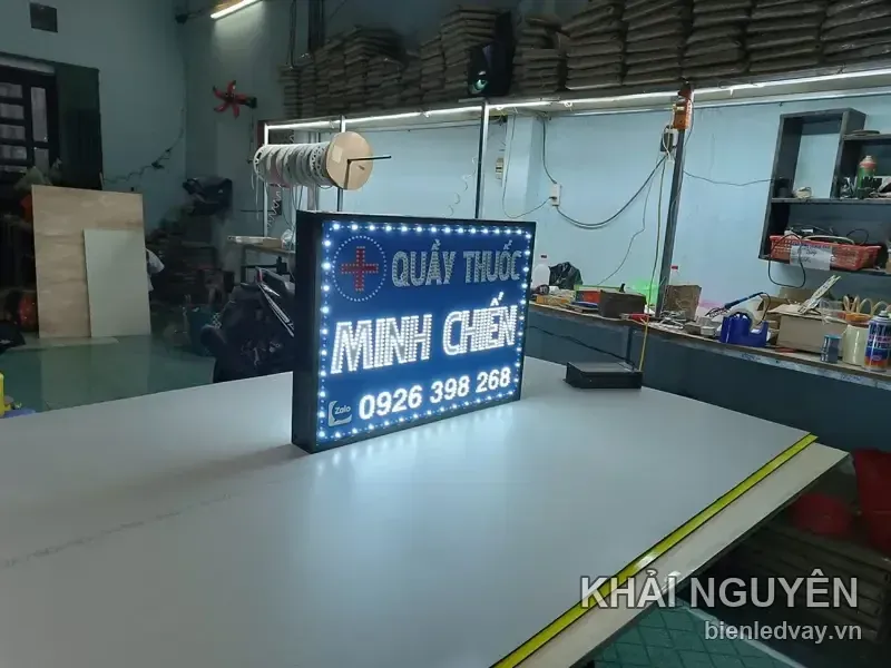 Biển vẫy Quầy Thuốc Minh Chiến nền xanh dương, chữ LED trắng, có số liên hệ qua Zalo và được chụp nghiêng