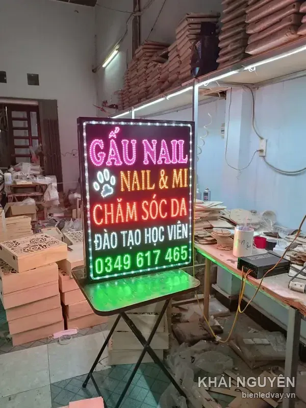 Biển vẫy LED Gấu Nail trên bàn gấp giữa xưởng gỗ