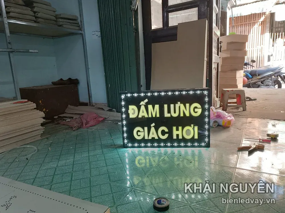 Biển vẫy chữ vàng ĐẤM LƯNG – GIÁC HƠI trên nền đen, viền LED bóng tròn trắng, đặt thử dưới nền xưởng