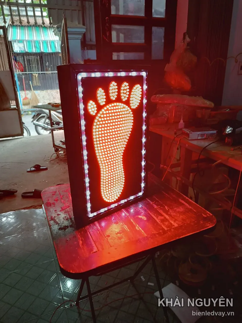 Biển vẫy massage hình bàn chân ghép LED trắng vàng trên nền đỏ, viền bóng tròn, khung đen, không có chữ