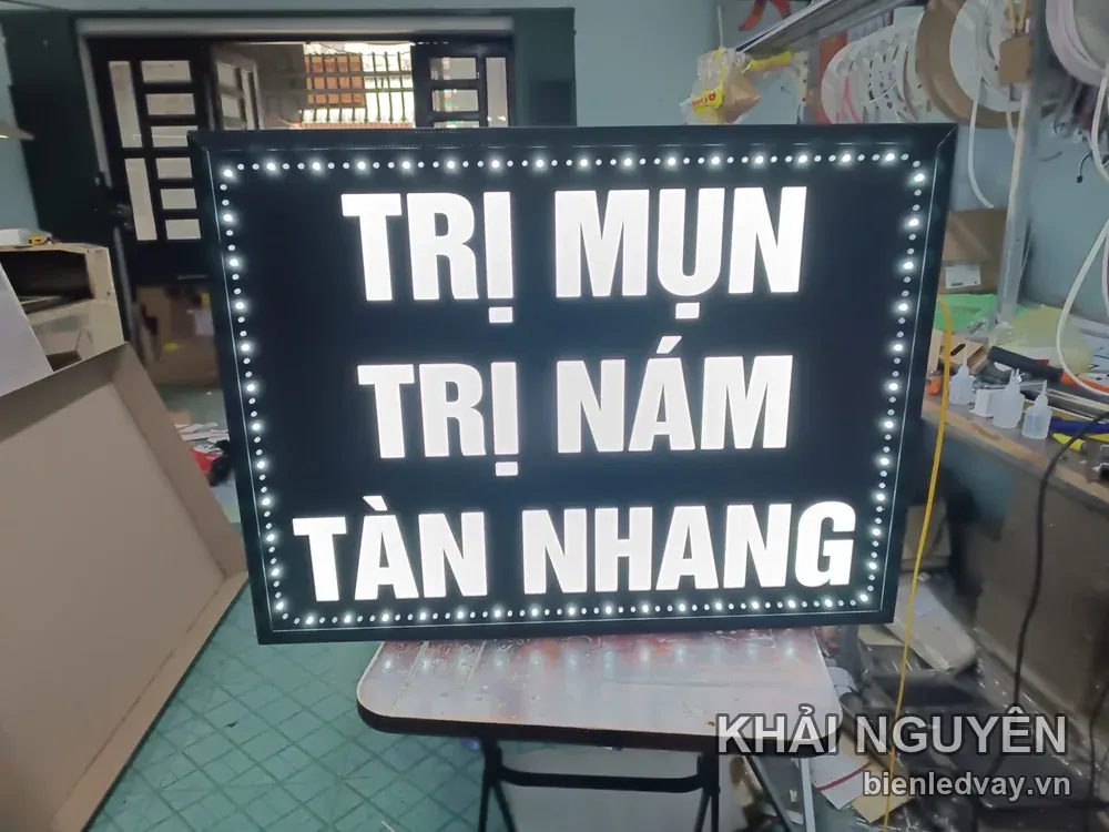 Biển vẫy TRỊ MỤN - TRỊ NÁM - TÀN NHANG chữ trắng trên nền đen, viền LED bóng tròn, chụp trong xưởng