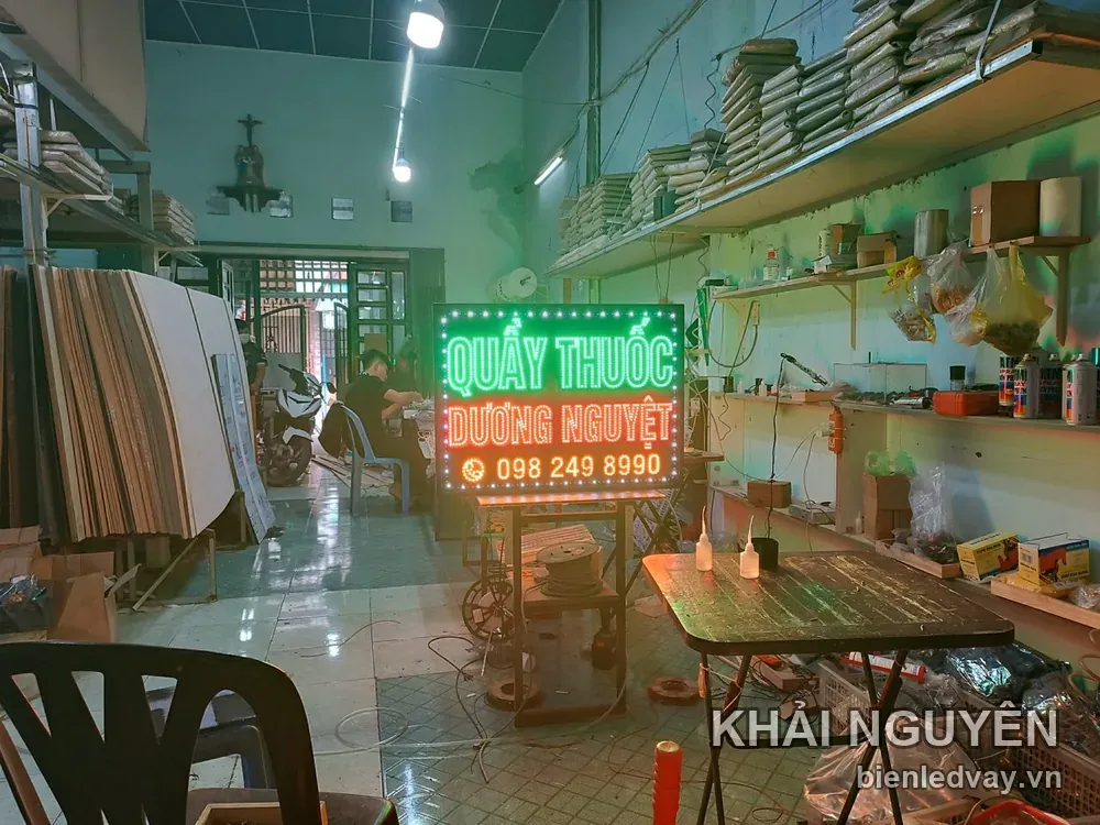 Biển vẫy Quầy Thuốc Dương Nguyệt chữ xanh lá và đỏ trên nền đen, viền LED bóng tròn, đặt trong xưởng