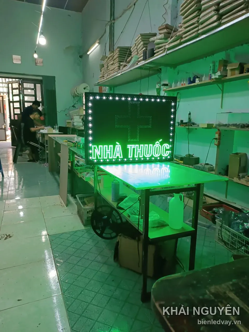 Biển vẫy Nhà Thuốc đặt trên xe đẩy, có chữ LED xanh lá, thập giá xanh nhấp nháy trên nền đen và viền bóng trắng