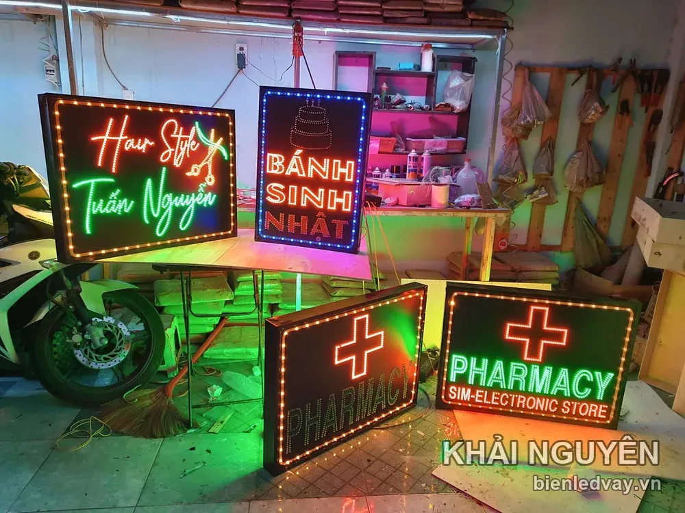 Bốn biển vẫy LED trong xưởng gồm hai biển Pharmacy chữ thập đỏ, một biển Hair Style Tuấn Nguyễn và một biển Bánh Sinh Nhật