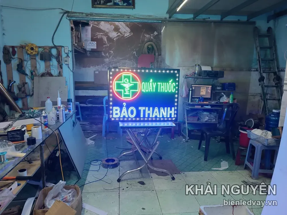 Biển vẫy Quầy Thuốc Bảo Thanh có chữ trắng, logo chữ thập xanh viền tròn đỏ, viền LED vàng và được đặt trên chân inox