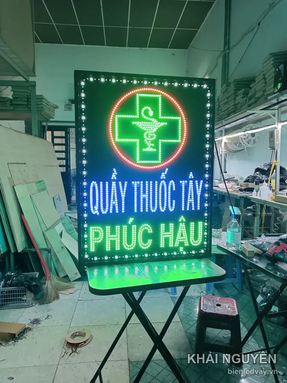 Biển vẫy có chữ thập xanh lá với rắn quấn ly, dòng QUẦY THUỐC TÂY xanh dương, PHÚC HẬU xanh lá và viền LED trắng