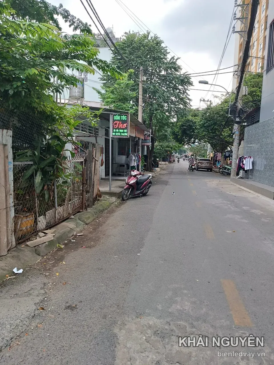 Biển vẫy Uốn Tóc Thơ lắp trên trụ trước tiệm bên đường
