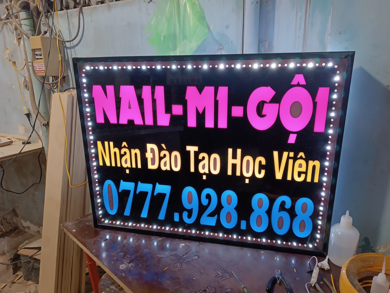 Biển LED tiệm nail có chữ Nail Mi Gội màu hồng trên nền đen