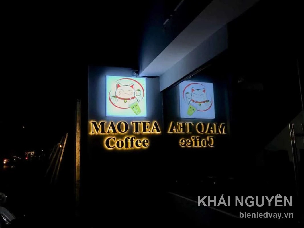 Hai hộp đèn Mao Tea Coffee hình mèo thần tài cùng chữ nổi hắt sáng vàng, chụp ban đêm sau khi lắp đặt