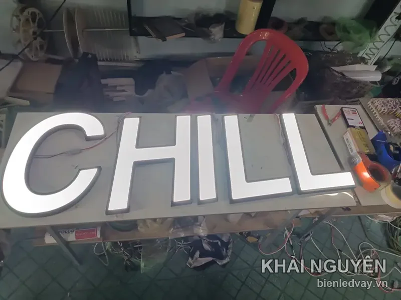 Bộ chữ nổi mica trắng ghép thành chữ CHILL, mặt mica dày hắt sáng, xếp trên bàn thi công tại xưởng