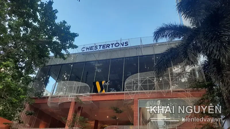 Chữ nổi Chestertons màu trắng gắn trên nóc tòa nhà kính, phía dưới là logo chữ W vàng trên mặt kính đen