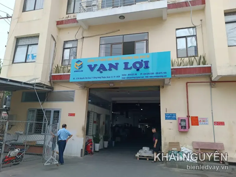 Bảng hiệu alu nền xanh ngọc VẠN LỢI gắn trên mặt tiền nhà xưởng, chữ nổi trắng kèm logo hộp giấy