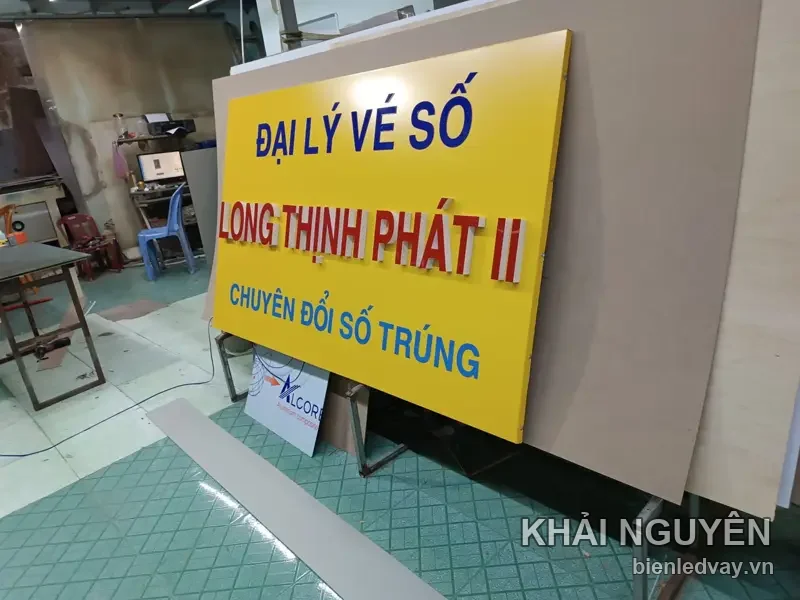 Chữ nổi mica LONG THỊNH PHÁT II màu đỏ trên nền alu vàng, kèm dòng ĐẠI LÝ VÉ SỐ và CHUYÊN ĐỔI SỐ TRÚNG chữ xanh