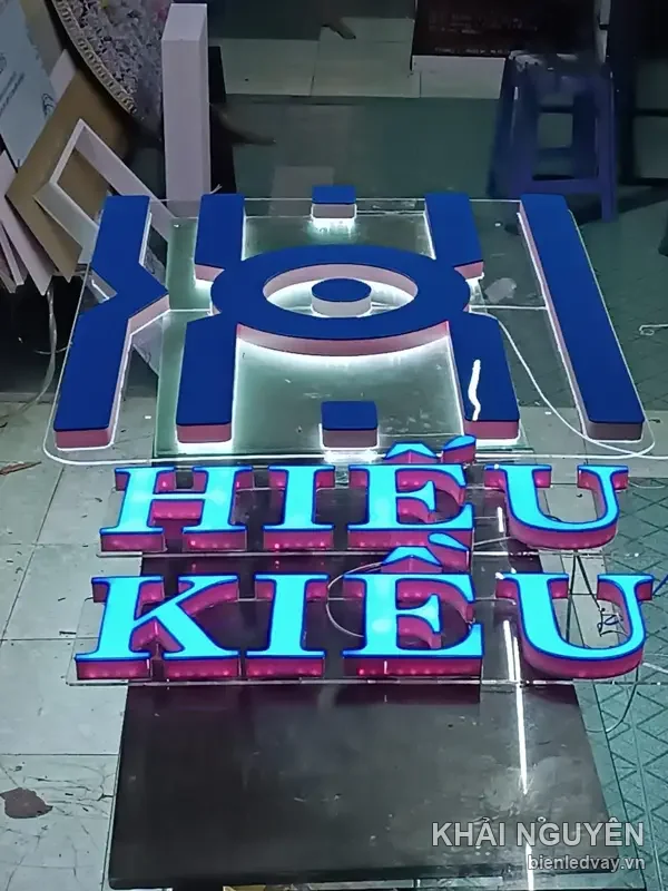 Chữ nổi mica HIẾU KIỀU xanh dương viền LED cyan cùng logo chữ H, đang chạy thử trên sàn xưởng