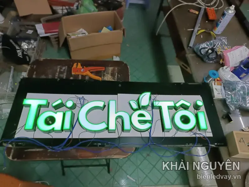 Chữ nổi mica Tái Chế Tôi chữ xanh lá kèm hình chiếc lá, đang đấu dây LED trên bàn trong xưởng