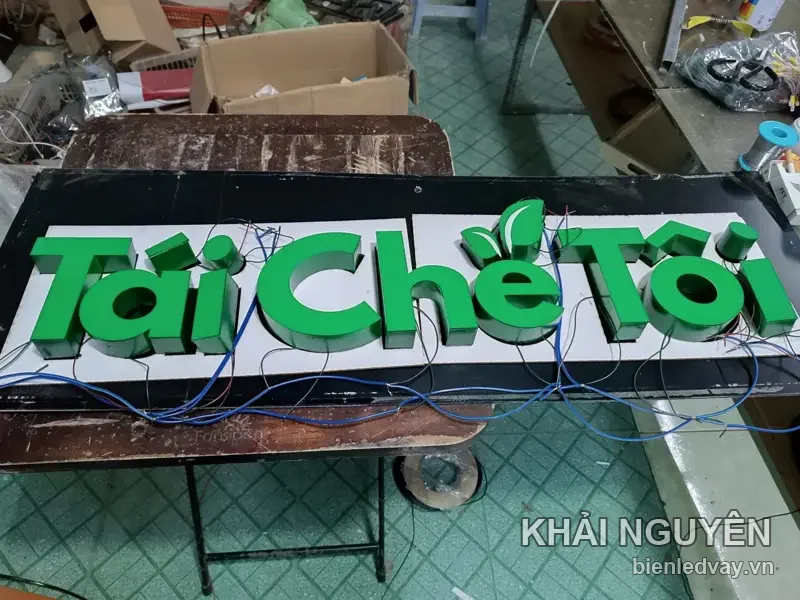 Chữ nổi mica xanh lá Tái Chế Tôi kèm hình lá cây, gắn trên panel nền trắng viền đen, dây LED còn chờ đấu