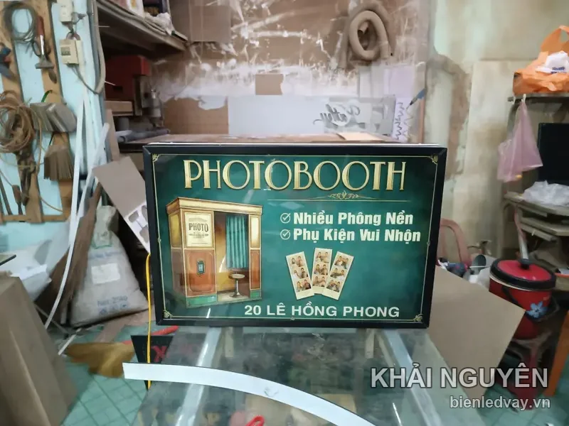 Hộp đèn PHOTOBOOTH nền xanh rêu chữ vàng đồng, hình buồng chụp ảnh và địa chỉ 20 Lê Hồng Phong