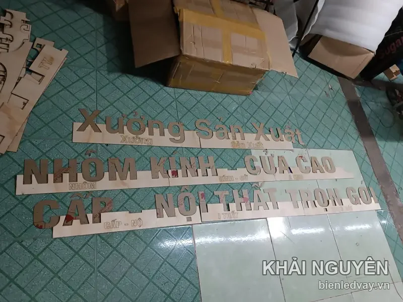 Bộ chữ mica vàng đồng Xưởng Sản Xuất Nhôm Kính - Cửa Cao Cấp - Nội Thất Trọn Gói xếp trên sàn chờ lắp