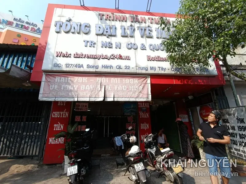 Bảng hiệu mặt tiền Trinh Van Tuan tổng đại lý vé máy bay, chữ nổi trắng trên nền đỏ kèm bạt hiflex quảng cáo
