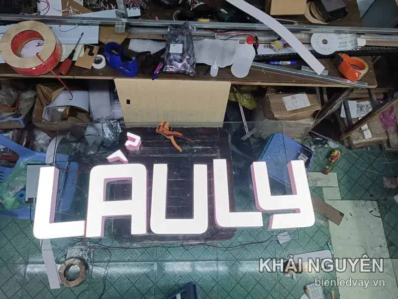Chữ nổi mica LẨULY mặt trắng thành hồng, đã gắn LED, nằm chờ lắp trên sàn xưởng Khải Nguyên