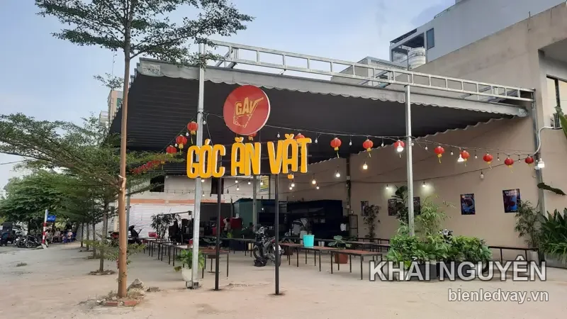 Chữ nổi GÓC ĂN VẶT màu vàng gắn trên khung sắt trước quán, logo GAV tròn đỏ, đèn lồng đỏ treo dọc mái bạt