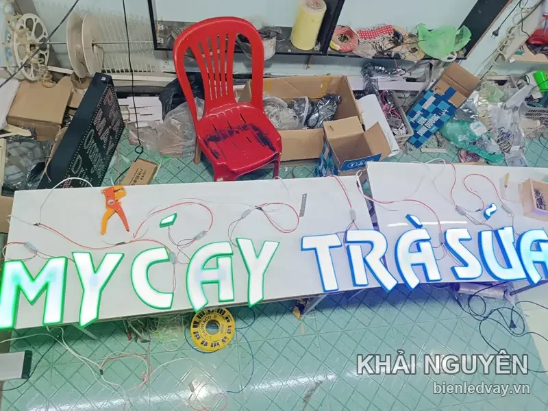 Chữ nổi mica Mỳ Cay Trà Sữa đang đấu dây LED tại xưởng, chữ trắng viền xanh lá và xanh dương