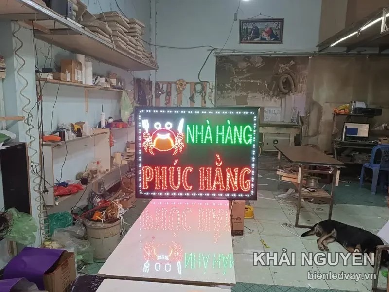 Biển vẫy NHÀ HÀNG PHÚC HẰNG sáng đèn giữa xưởng