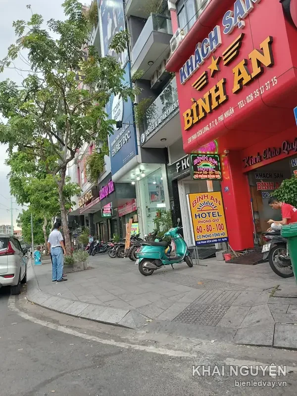 Chữ nổi KHÁCH SẠN BÌNH AN trên tường đỏ đường Phan Xích Long, bên dưới có biển vẫy LED bảng giá phòng giờ