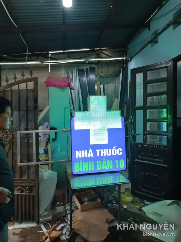 Biển chữ thập nhà thuốc BÌNH DÂN 10 nền xanh dương chụp cận, chữ thập LED ma trận trắng, mặt hộp phẳng