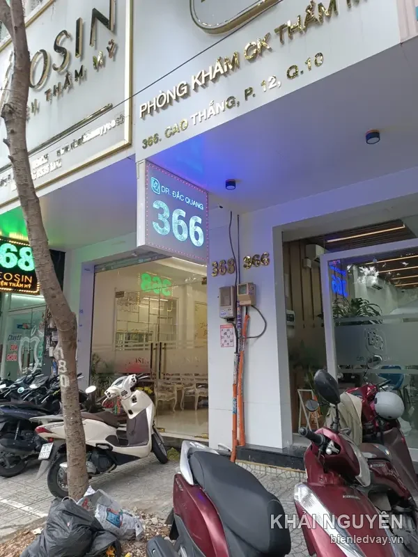 Hộp đèn số 366 chữ trắng nền xanh của Dr. Đắc Quang treo dưới mái hiên phòng khám thẩm mỹ đường Cao Thắng