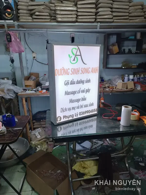 Hộp đèn DƯỠNG SINH SONG ANH nền trắng chữ cam, logo SA xanh, ghi massage cổ vai gáy và massage bầu