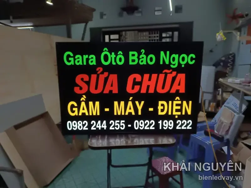 Biển Gara Ôtô Bảo Ngọc chụp cận trên giá gấp, số liên hệ trên biển- số liên hệ trên biển chữ trắng dưới cùng
