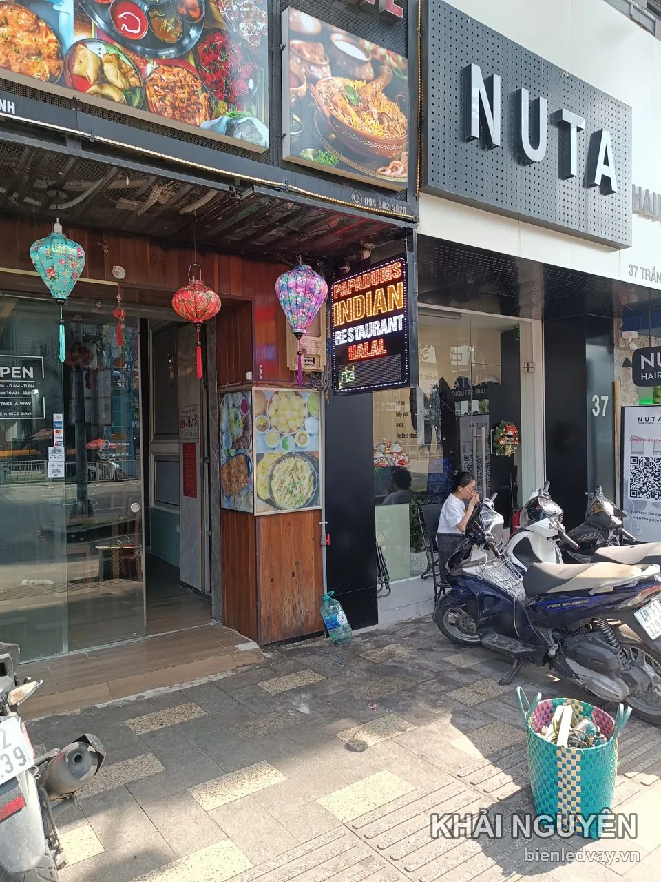 Biển vẫy Papadums Indian Restaurant Halal treo vuông góc trước cửa quán